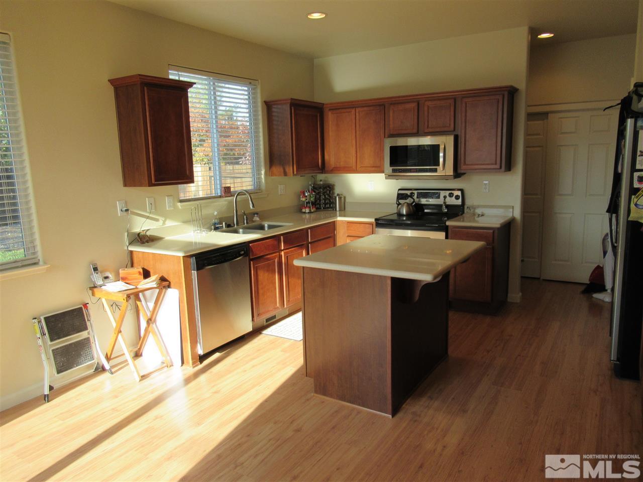 2347 Clementine Lane Reno, NV 89521 - Photo 6 of 19 a kitchen with stainless steel appliances granite countertop a sink a stove a refrigerator cabinets and wooden floor