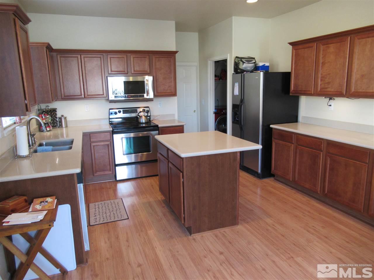 2347 Clementine Lane Reno, NV 89521 - Photo 7 of 19 a kitchen with stainless steel appliances wooden floors a stove and wooden cabinets