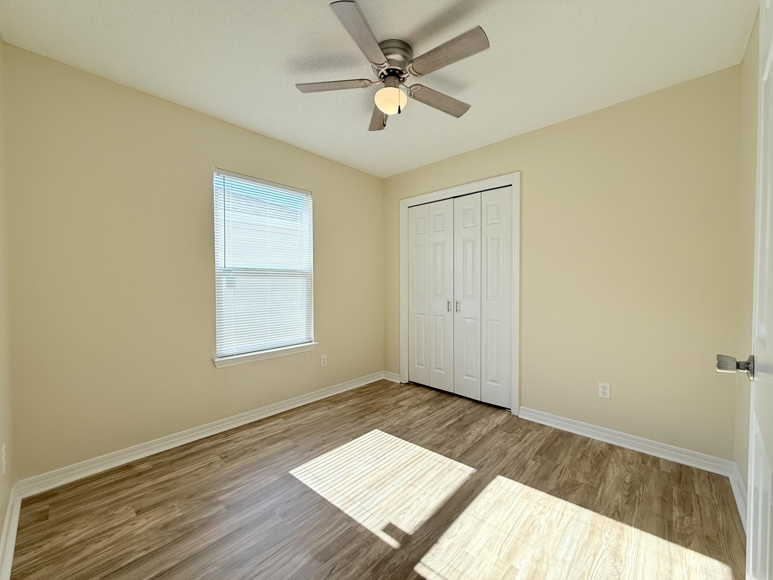 7612 Chablis Circle Navarre, FL 32566 - Photo 11 of 16 wooden floor in an empty room with a window