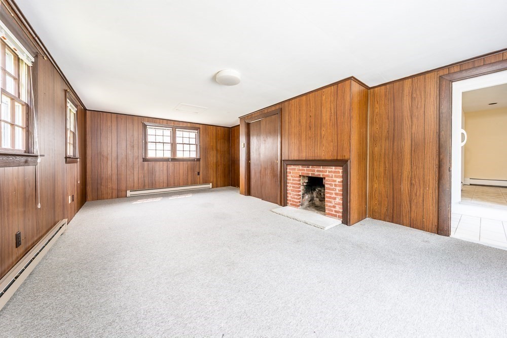 22 Beach View Road Dennis, MA 02670 - Photo 29 of 42 a view of an empty room with a fireplace and windows