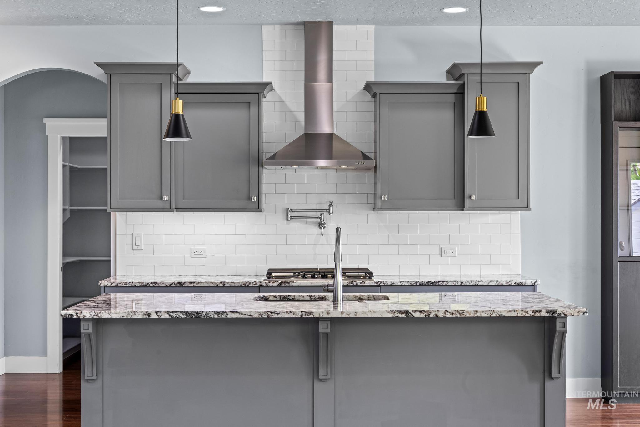 2681 East Rhyolite Court Nampa, ID 83686 - Photo 11 of 48 Kitchen island with a granite countertop and gray shaker-style cabinetry
