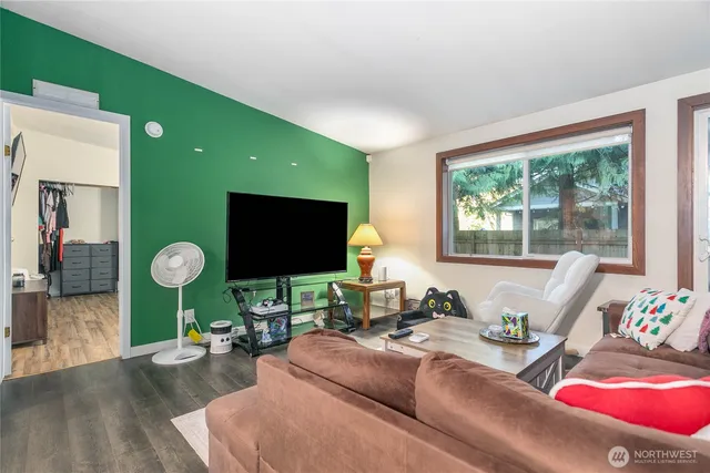 a living room with furniture a window and a flat screen tv