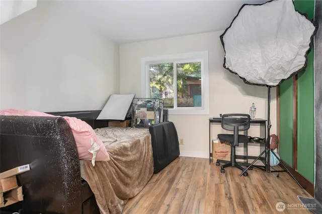 a bedroom with a bed and wooden floor
