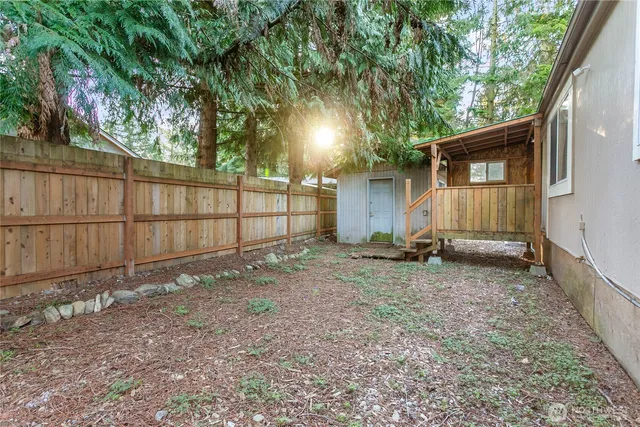 a view of backyard and wooden fence