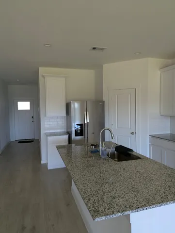 a kitchen with a sink a counter top space and cabinets