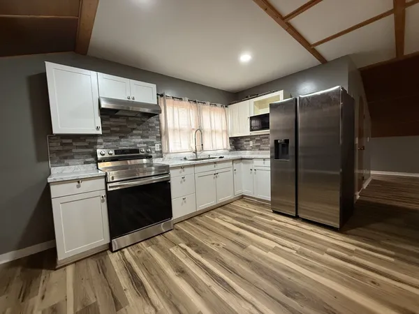 a kitchen with a sink stainless steel appliances and cabinets