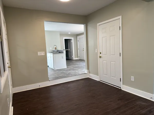 an empty room with wooden floor and window