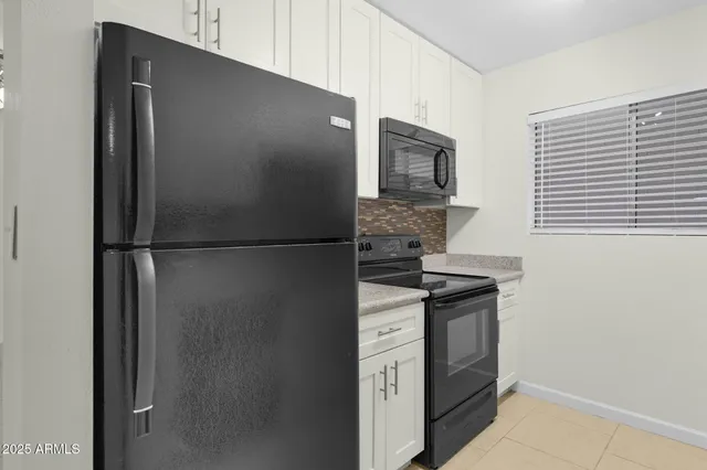 a kitchen with stainless steel appliances granite countertop a refrigerator and a stove