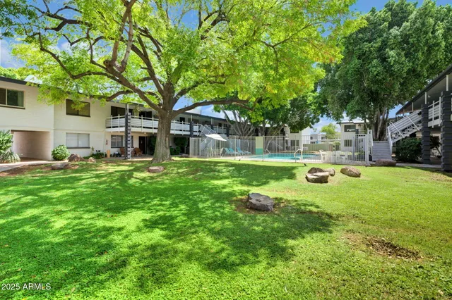 a view of a house with a big yard and large trees