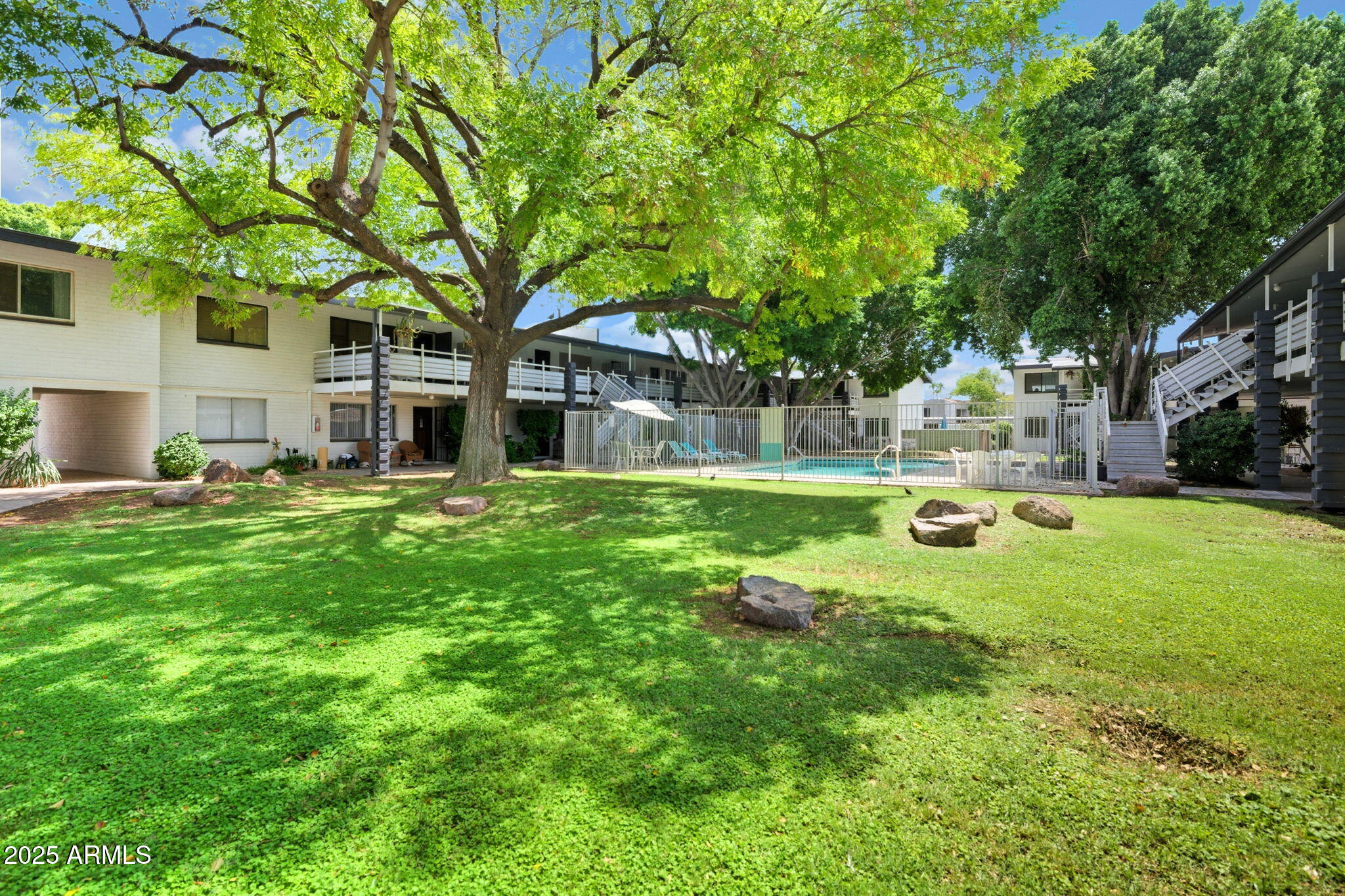749 East Montebello Avenue, Unit 127 Phoenix, AZ 85014 - Photo 20 of 20 a view of a house with a big yard and large trees