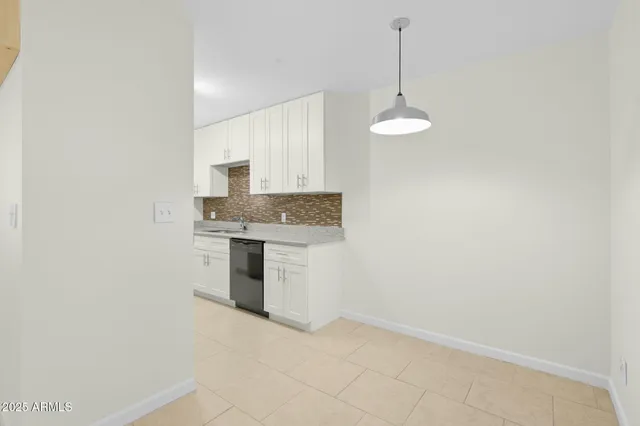 a kitchen with granite countertop white cabinets and stainless steel appliances