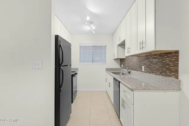 a kitchen with stainless steel appliances granite countertop a sink and a refrigerator