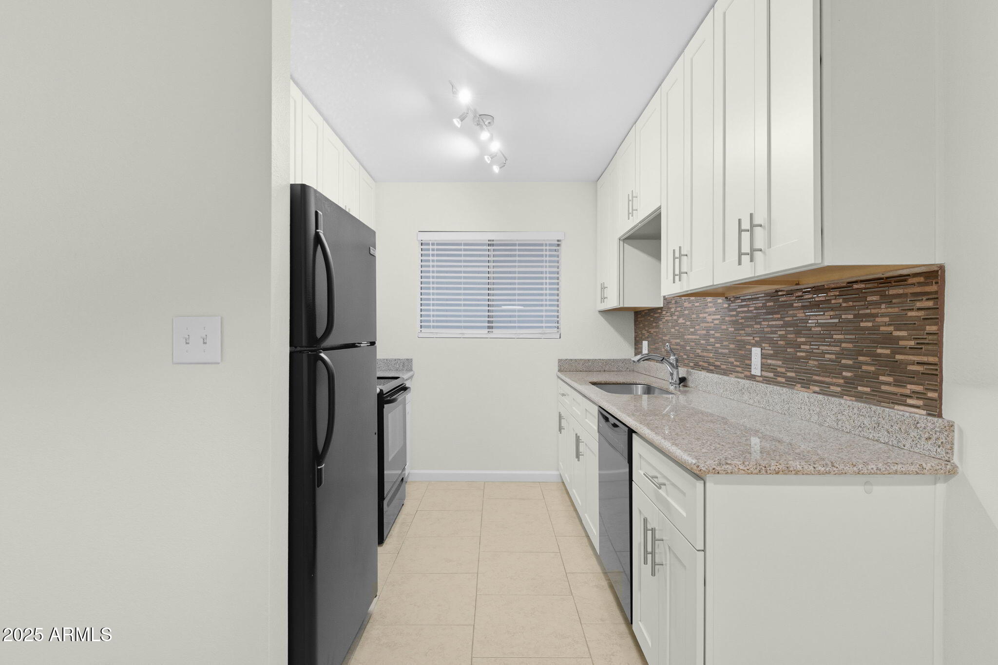 749 East Montebello Avenue, Unit 127 Phoenix, AZ 85014 - Photo 9 of 20 a kitchen with stainless steel appliances granite countertop a sink and a refrigerator