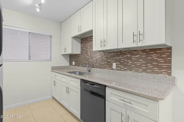 a kitchen with stainless steel appliances granite countertop white cabinets and a sink