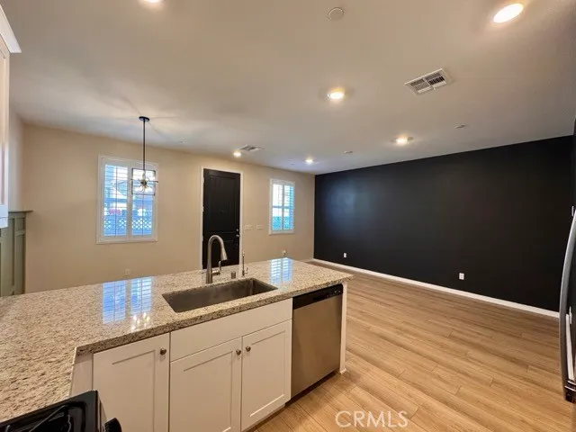 a kitchen with stainless steel appliances granite countertop a refrigerator a sink and a stove