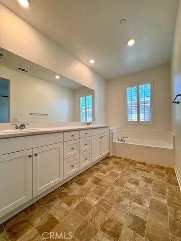 a spacious bathroom with a double vanity sink and a mirror