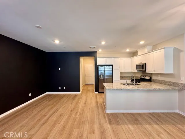 a large kitchen with kitchen island a sink a stove and wooden floors
