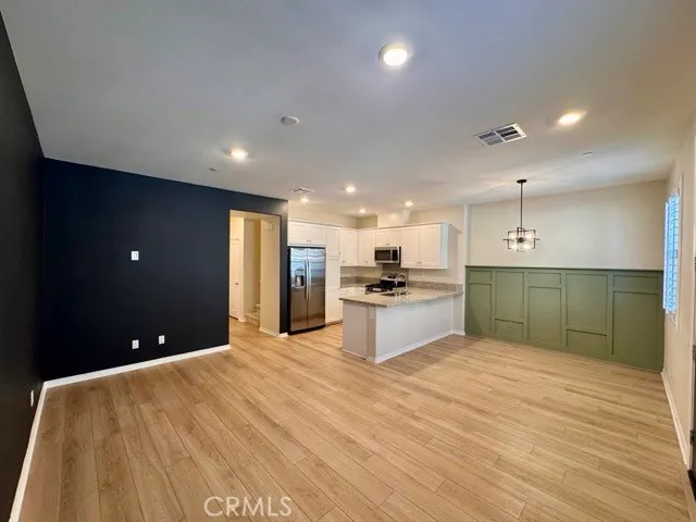 a view of kitchen with kitchen island granite countertop stainless steel appliances refrigerator stove microwave and cabinets