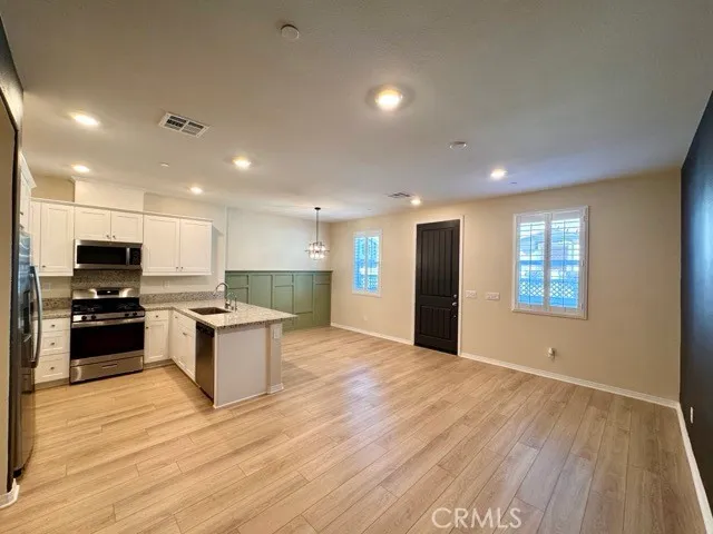 a kitchen with stainless steel appliances granite countertop a stove a sink and a refrigerator