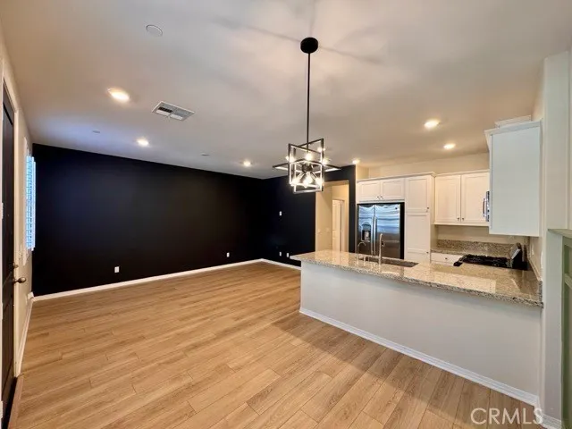 a kitchen with granite countertop a refrigerator and a sink