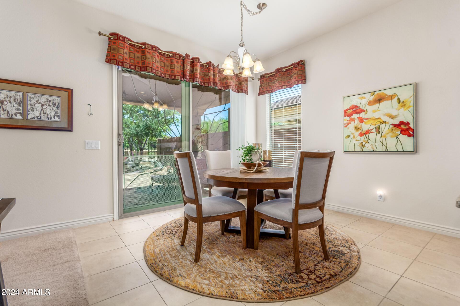 17858 West Verdin Road Goodyear, AZ 85338 - Photo 12 of 78 a dining room with furniture a rug and a chandelier