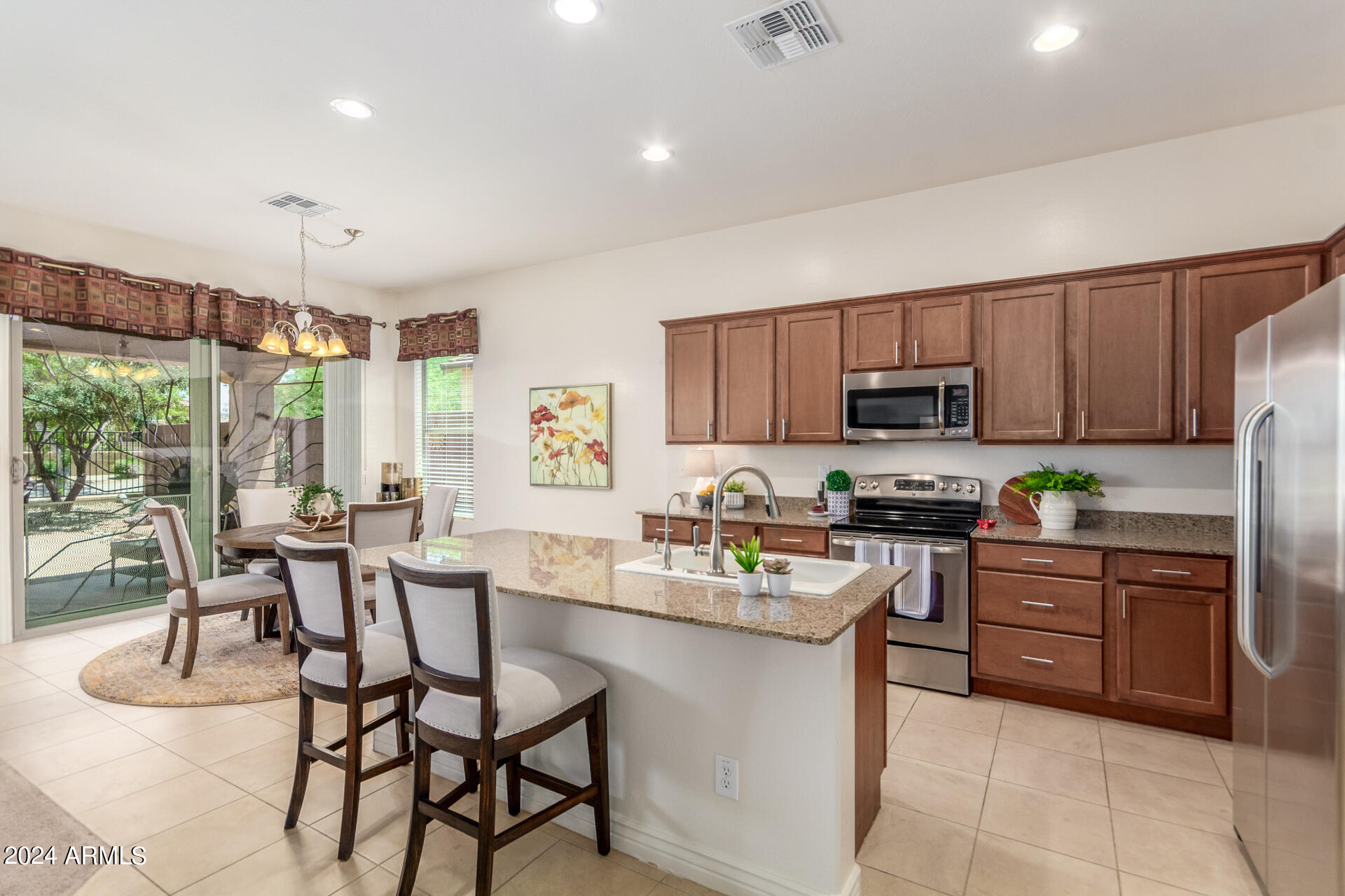17858 West Verdin Road Goodyear, AZ 85338 - Photo 13 of 78 a kitchen with stainless steel appliances granite countertop wooden cabinets a stove top oven a sink and dishwasher