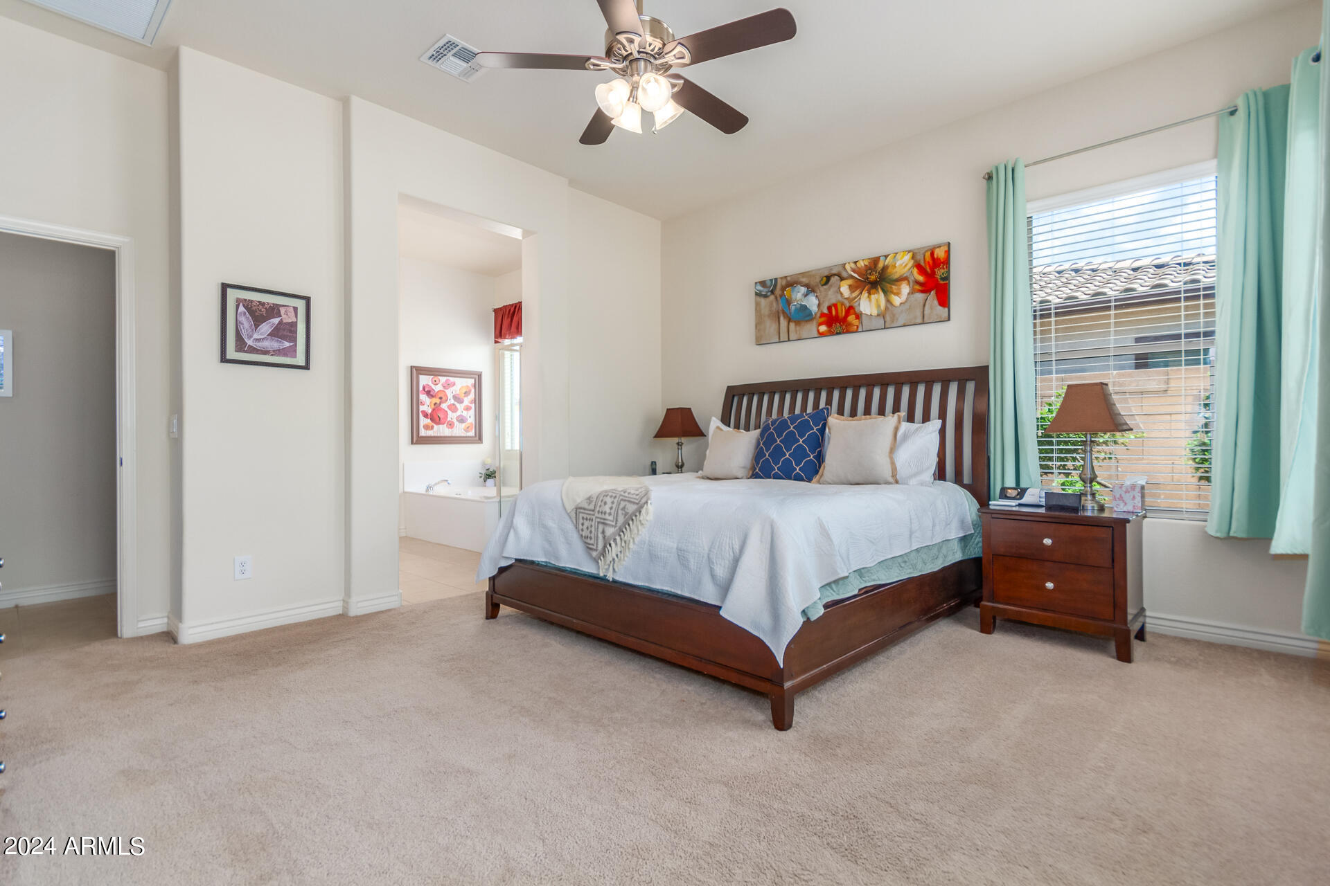 17858 West Verdin Road Goodyear, AZ 85338 - Photo 17 of 78 a bedroom with a bed and a chandelier