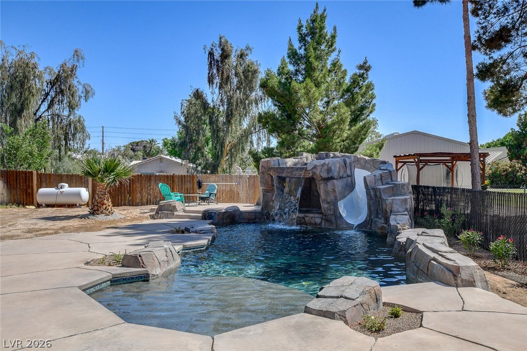 3765 Berkeley Street Logandale, NV 89021 - Photo 79 of 87 An inviting backyard oasis features a custom rock pool with a thrilling waterslide and waterfall.