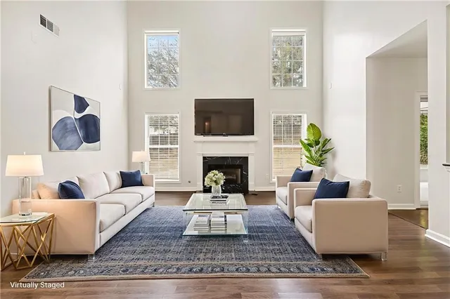 a living room with furniture a flat screen tv and a fireplace