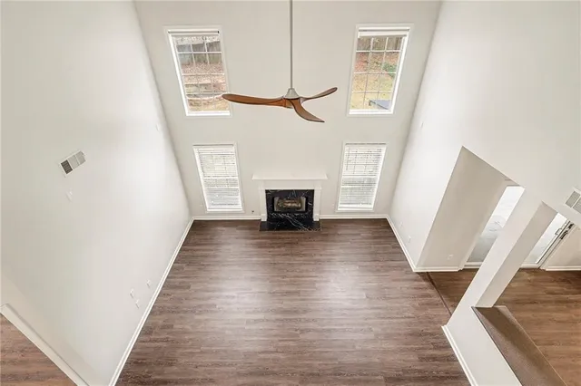 a view of a livingroom with wooden floor and a ceiling fan