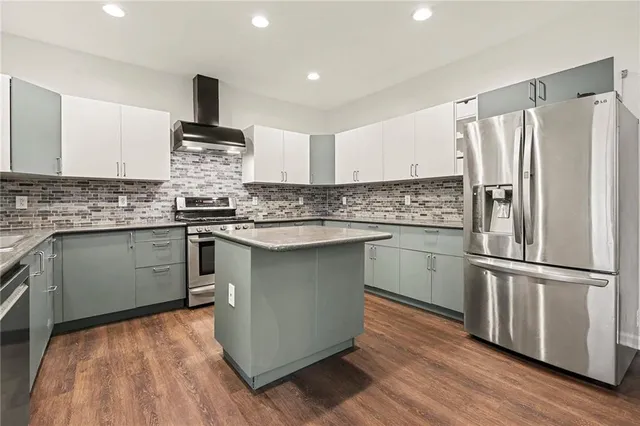 a kitchen with stainless steel appliances granite countertop a refrigerator a sink dishwasher a stove and a refrigerator