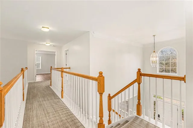 a view of a hallway with wooden floor and staircase