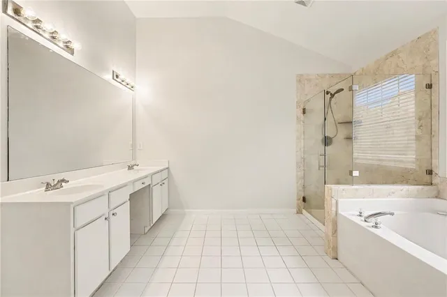 a bathroom with a tub a sink a mirror and a shower