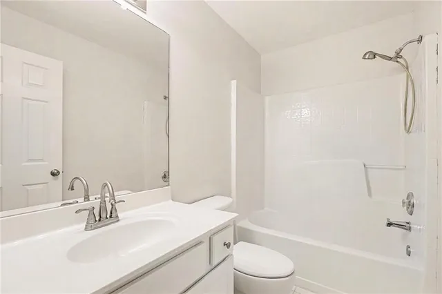 a bathroom with a sink toilet vanity and shower