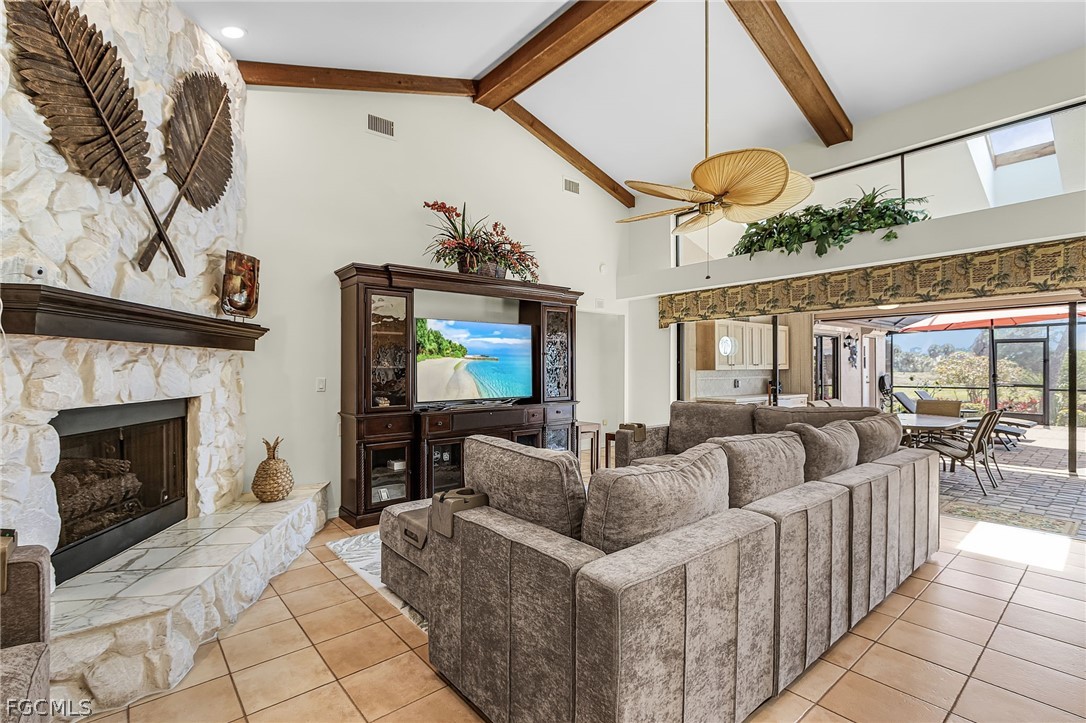 7747 Grande Pine Road Bokeelia, FL 33922 - Photo 17 of 45 a living room with furniture a fireplace and a flat screen tv