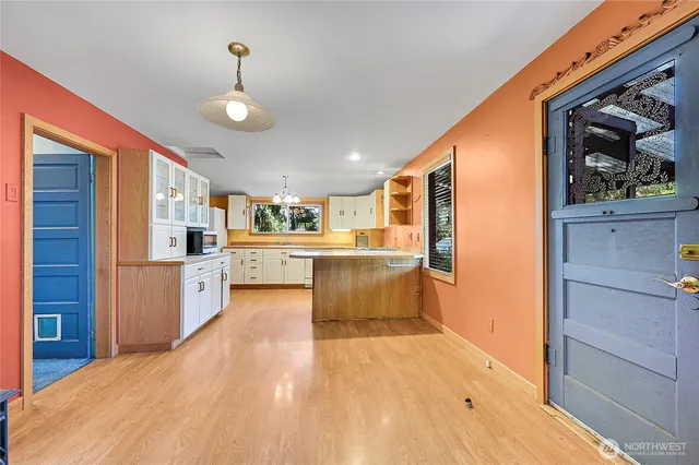 a large kitchen with a lot of counter space and wooden floor