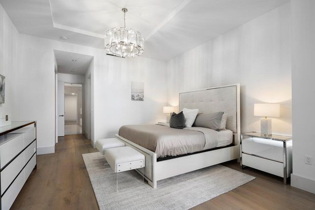 a large white kitchen with a lot of counter space and wooden floor