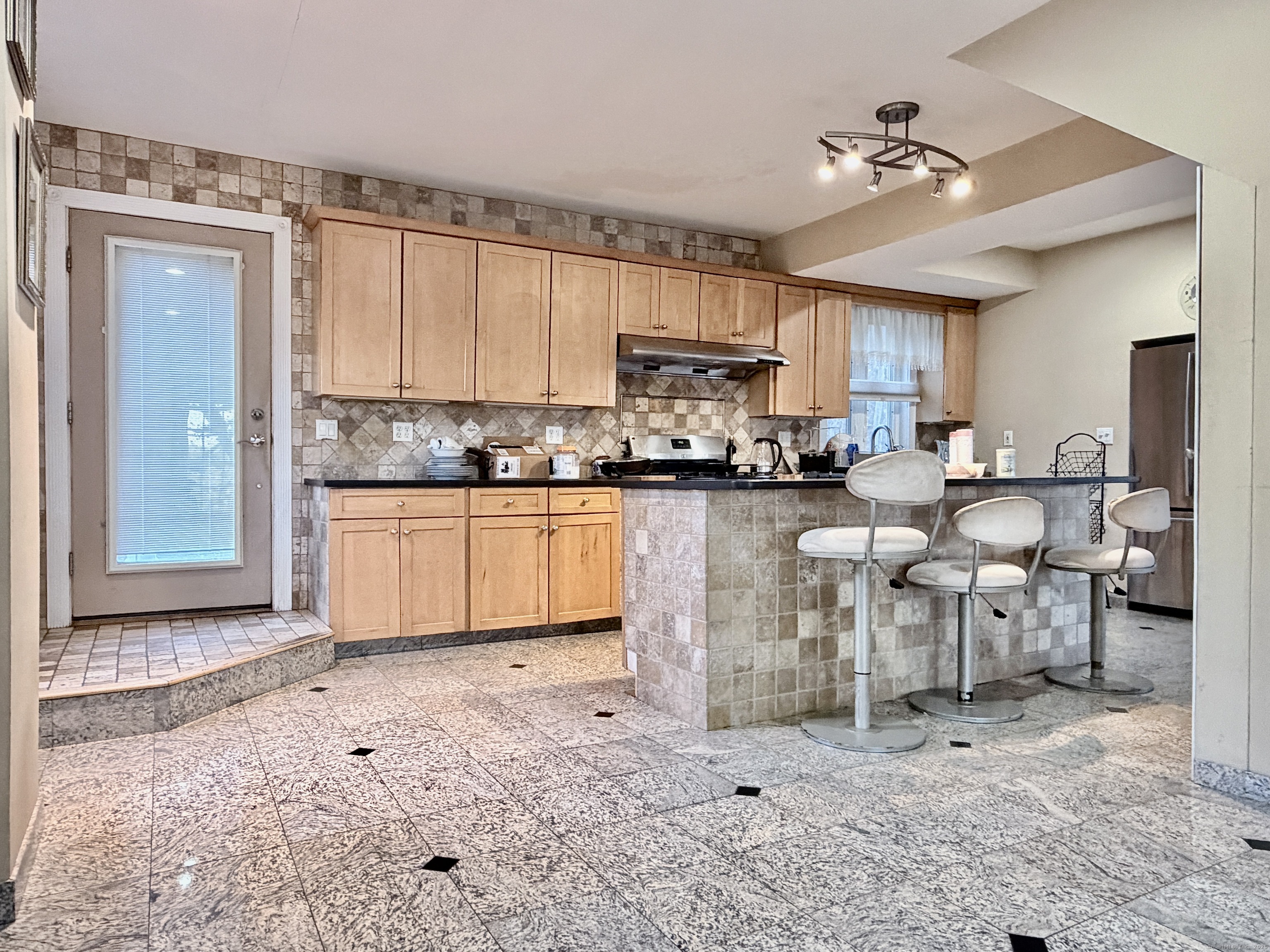 88 Rocky Rest Road Shelton, CT 06484 - Photo 3 of 21 a open kitchen with stainless steel appliances granite countertop a stove top oven a sink a dining table and chairs