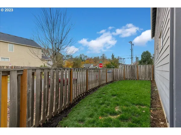 a view of a backyard with wooden fence