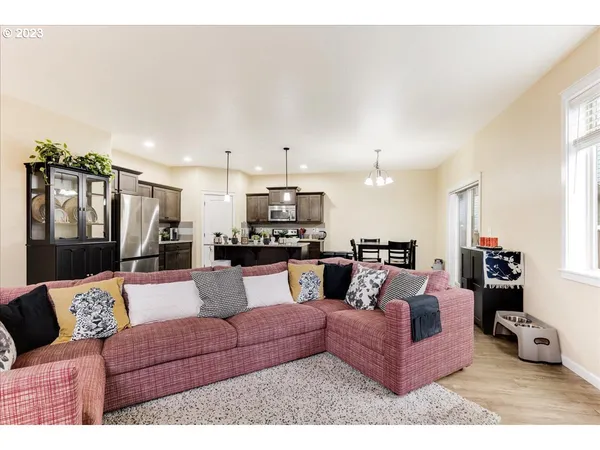 a living room with furniture and a view of kitchen