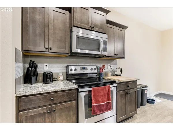 a kitchen with granite countertop cabinets stainless steel appliances and wooden floor