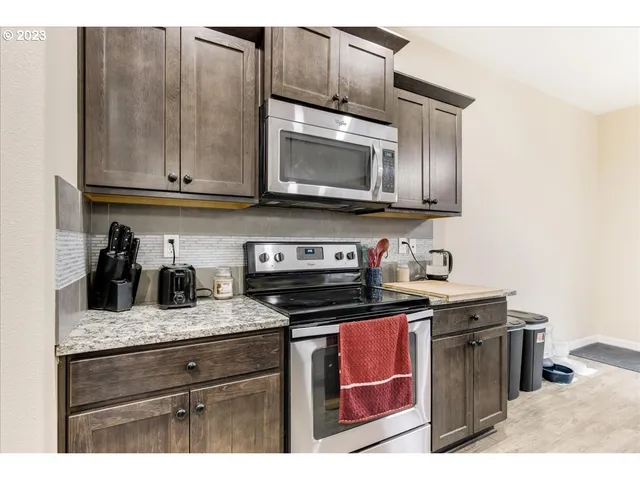 a kitchen with granite countertop cabinets stainless steel appliances and wooden floor