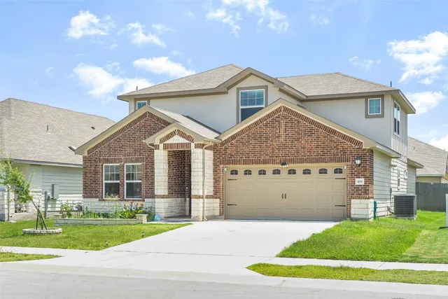 a view of a big house with a big yard and large trees