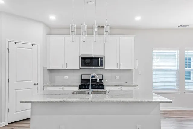a kitchen with white cabinets and stainless steel appliances