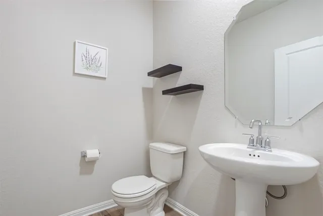 a bathroom with a toilet sink and mirror