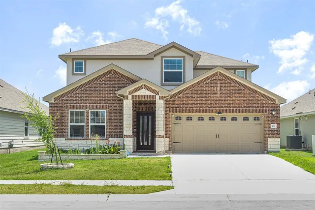 a front view of a house with a garden and plants