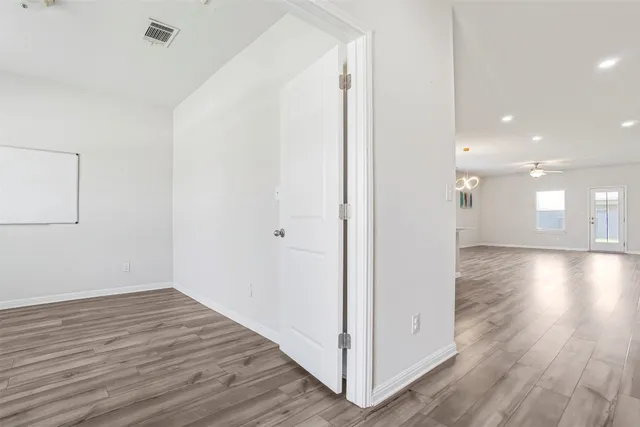 an empty room with a ceiling fan and a window