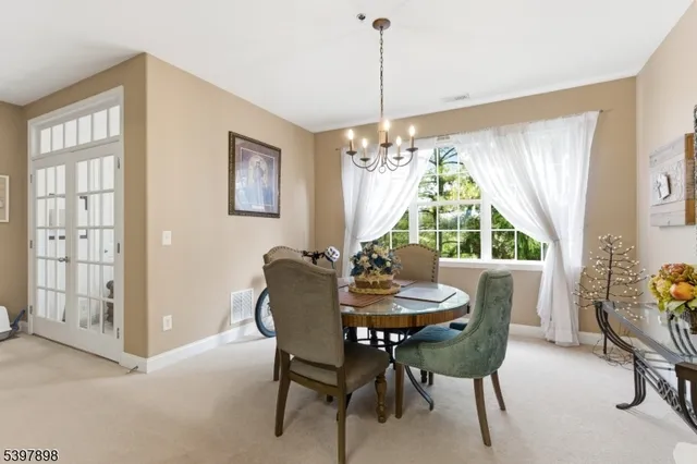 a dining room with furniture a chandelier and wooden floor