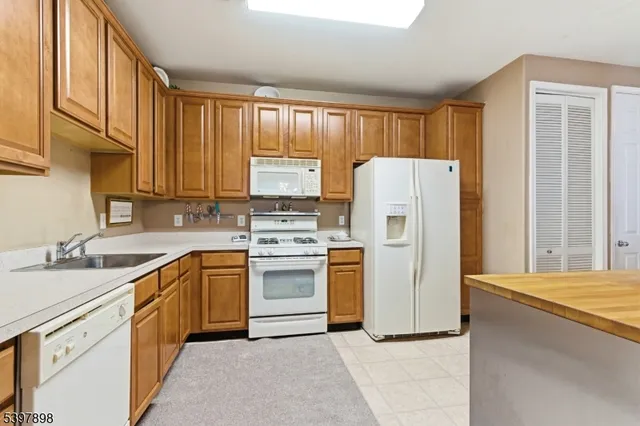 a kitchen with stainless steel appliances granite countertop a refrigerator sink and stove