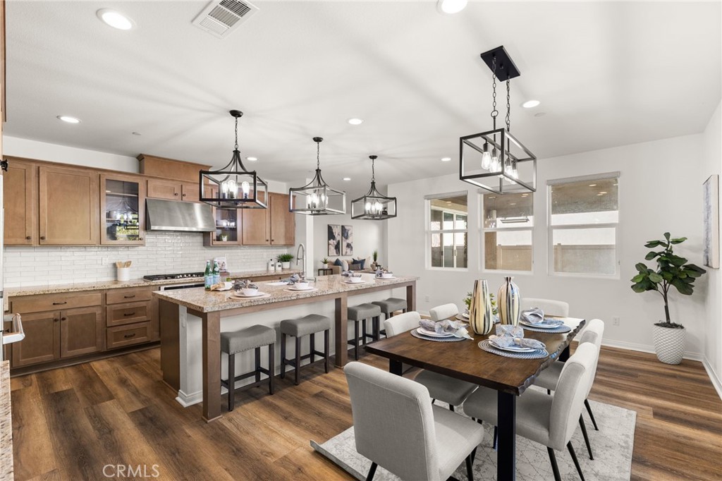 32448 Toyon Road Temecula, CA 92591 - Photo 14 of 72 a kitchen with stainless steel appliances a dining table chairs stove and white cabinets
